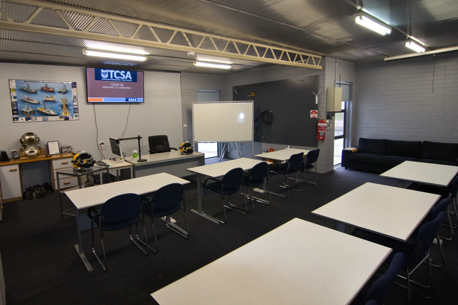 UTCSA theory classroom set up for a Combined SCUBA and SSBA to 30m (Part 1 & 2) induction, with Kirby Morgan helmets and a heritage diving helmet on display